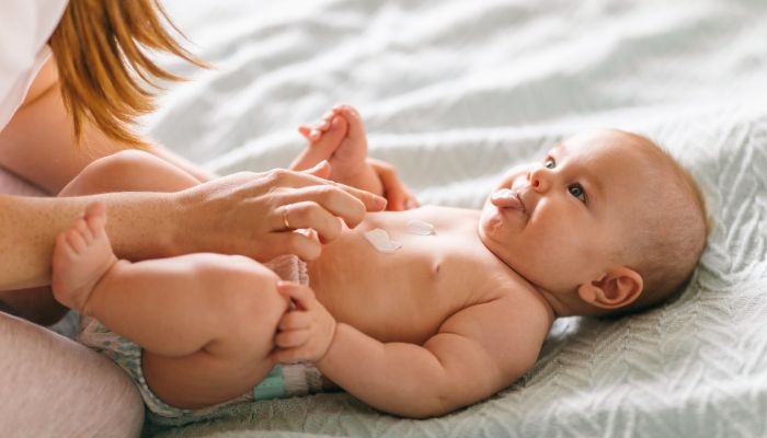maman qui met de la crème sur la peau de bébé maman qui met de la crème sur la peau de bébé