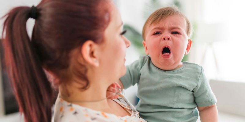 maman qui hésite à mettre un oignon sous le lit de son bébé qui tousse beaucoup